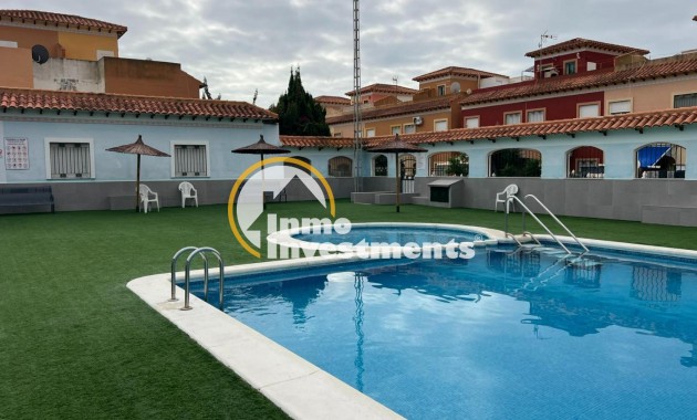 Gemeinschaftlicher Außenpool mit Leiter und Kunstrasen in einer Bungalowanlage in Torrevieja, Spanien