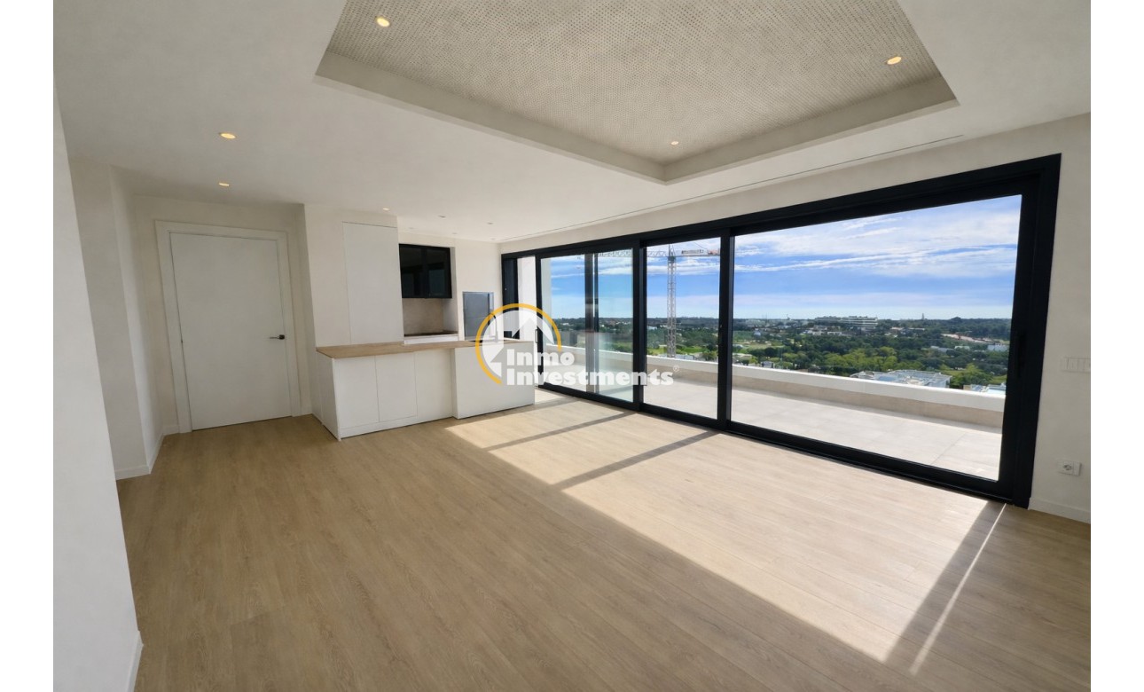 Großzügiger Wohnbereich in einer Wohnung in Orihuela Costa, offener Grundriss, heller Bodenbelag, große verglaste Türen und panoramischer Küstenblick