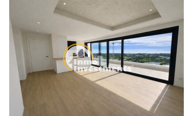 Großzügiger Wohnbereich in einer Wohnung in Orihuela Costa, offener Grundriss, heller Bodenbelag, große verglaste Türen und panoramischer Küstenblick