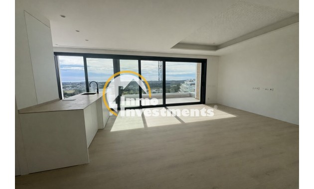 Offenes Wohnzimmer mit Kücheninsel und bodentiefen Fenstern in einer Wohnung in Orihuela Costa, Spanien, mit Meerblick