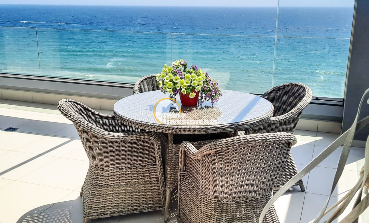 Matgrupp för terrassen med havsutsikt på Punta Prima-penthousebalkong med glasräcke och medelhavskuliss