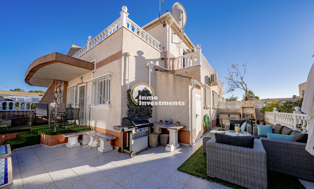 Quad house exterior in Cabo Roig with tiled courtyard, awnings, balustrade terrace and satellite dish