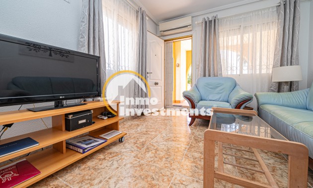 Living room in La Zenia apartment with TV unit, glass coffee table, leather sofas and patio doors to terrace