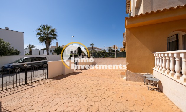 Paved front terrace and driveway at La Zenia apartment with gated entrance, palm tree and street parking