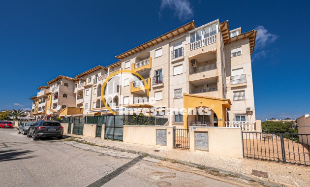 Apartment block exterior with balconies and gated frontage in La Zenia, Spain under clear blue sky