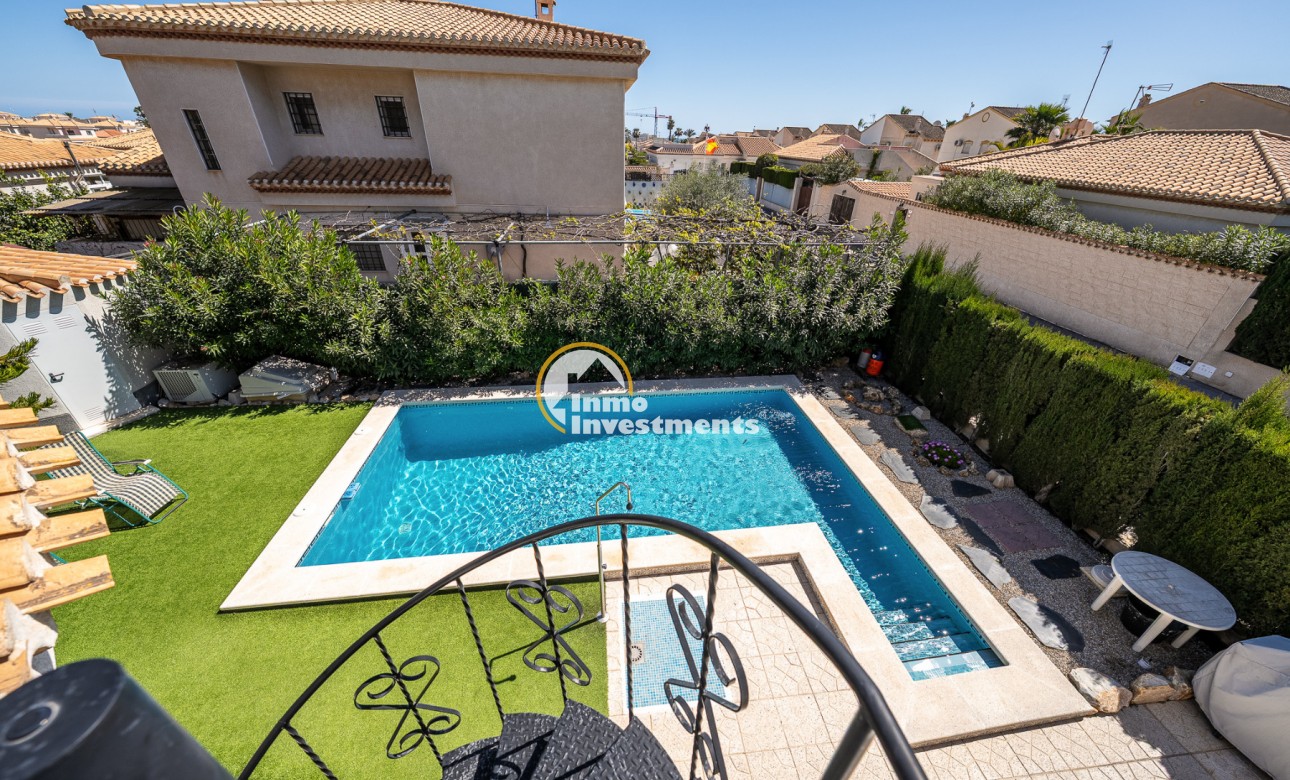 Privater Swimmingpool und geflieste Terrasse in Villa in Playa Flamenca, mit Kunstrasen und gewachsener Hecke