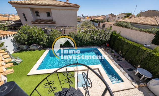 Privater Swimmingpool und geflieste Terrasse in Villa in Playa Flamenca, mit Kunstrasen und gewachsener Hecke