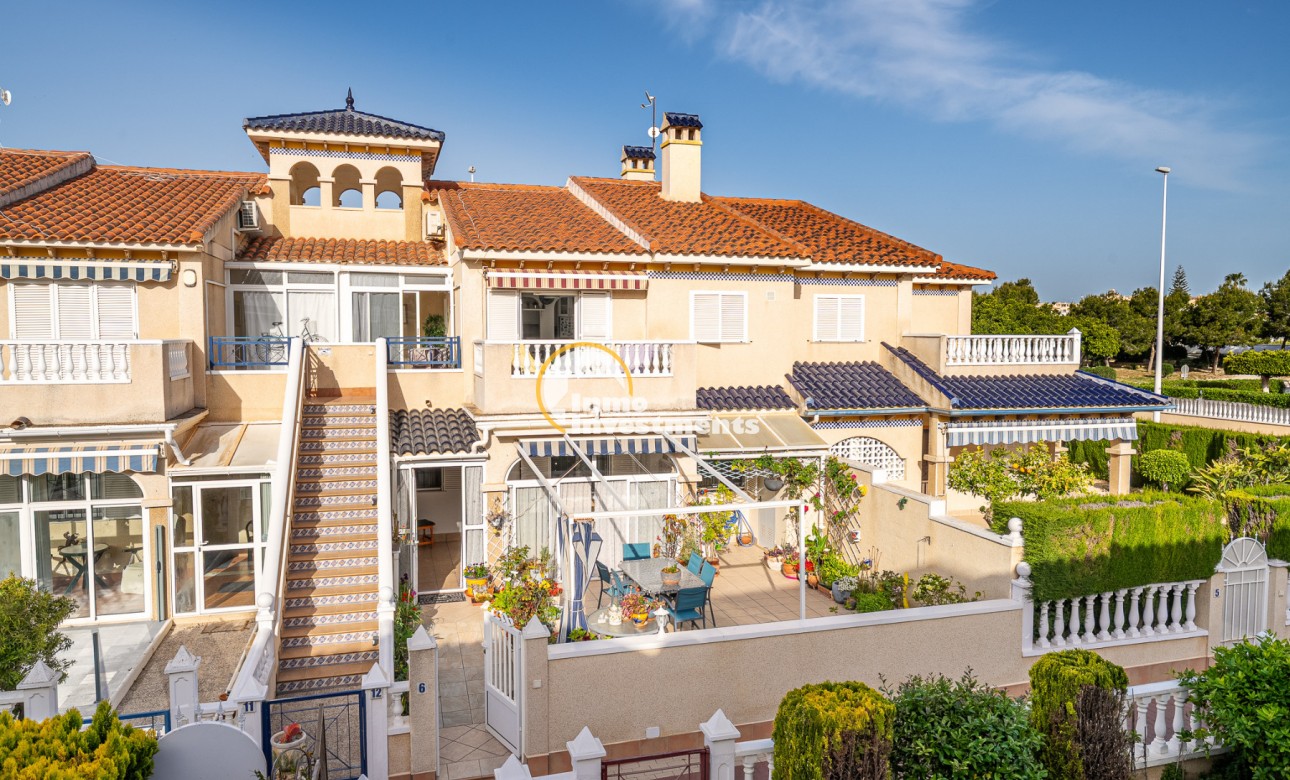 Playa Flamenca apartment exterior with tiled roof, balcony, sun terrace and external staircase under clear blue sky
