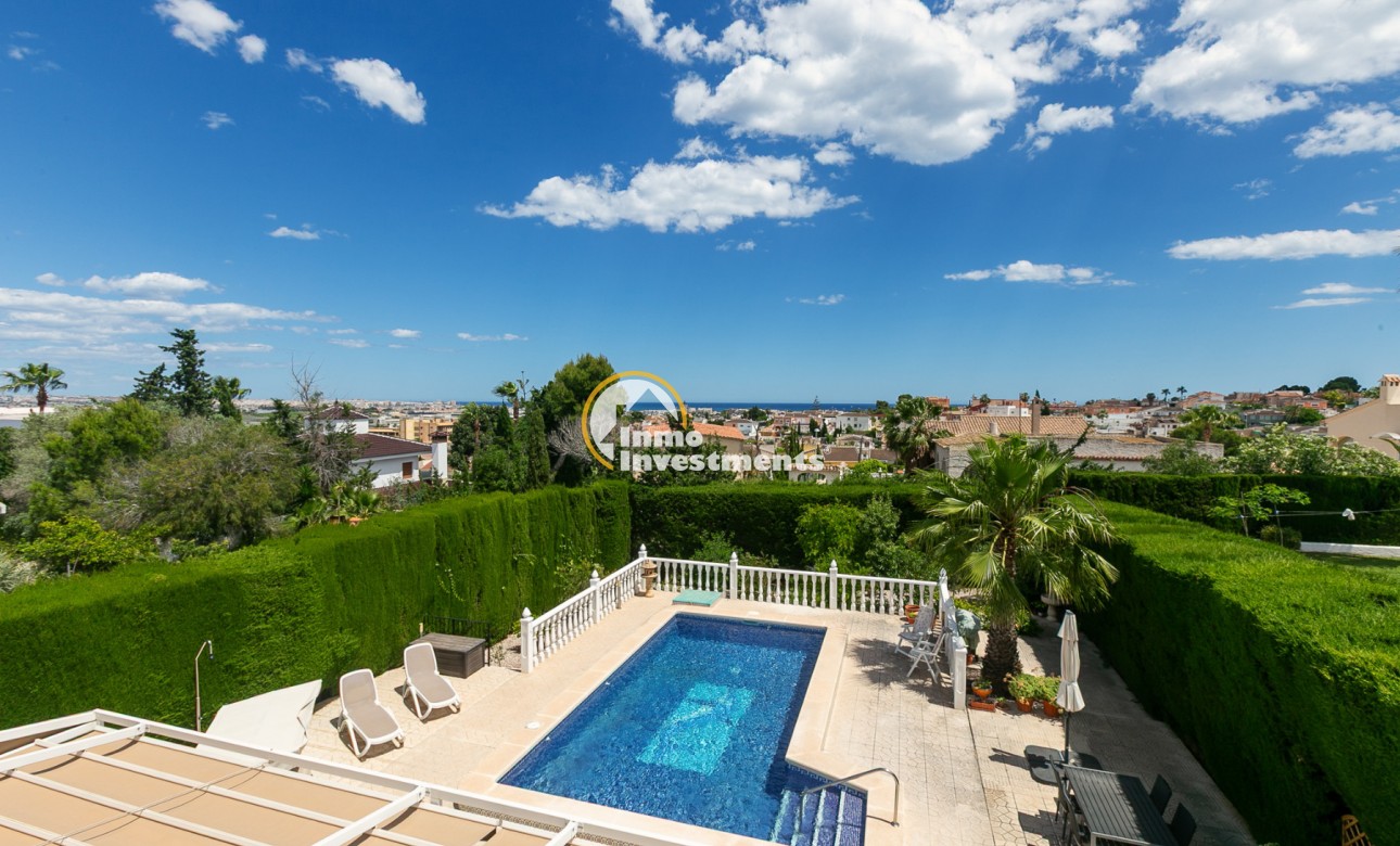 Pool terrace of semi-detached villa in Los Balcones, Spain, with sun loungers, hedged garden and panoramic sea views