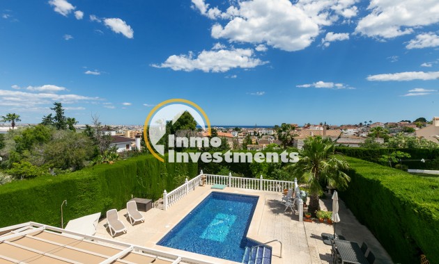 Pool terrace of semi-detached villa in Los Balcones, Spain, with sun loungers, hedged garden and panoramic sea views