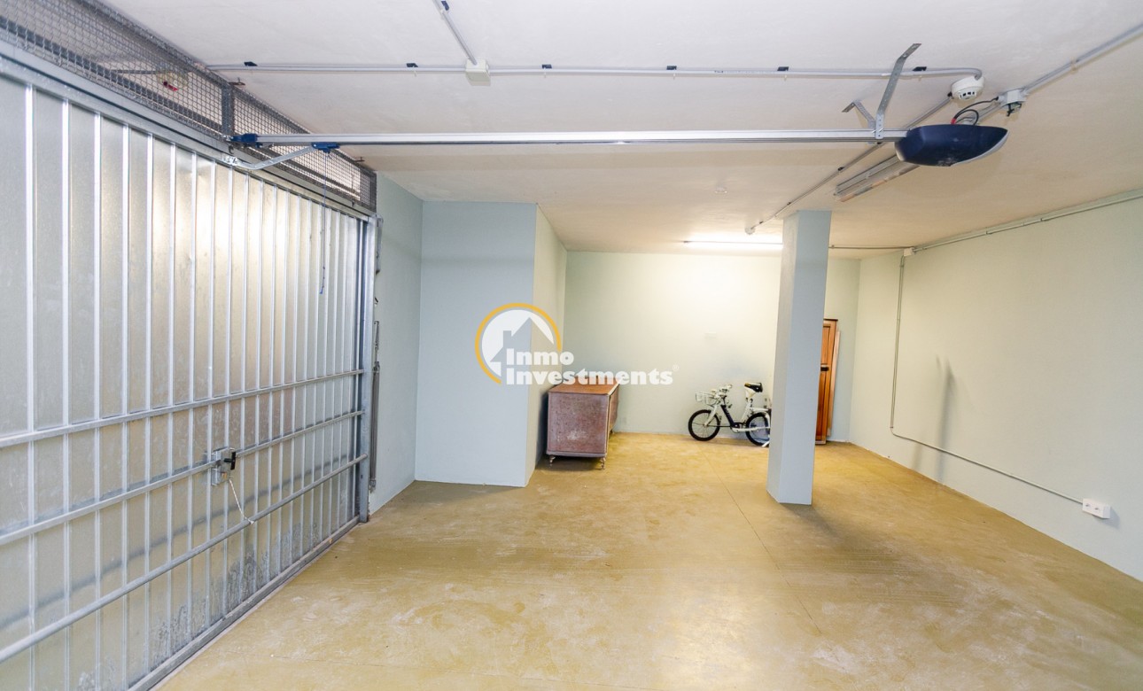 Spacieux garage de maison quadruple à Mil Palmeras, Espagne, avec sol en béton, pilier de soutien et éclairage au plafond