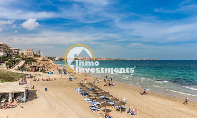 Beach and Mediterranean sea view near Mil Palmeras apartment, with sun loungers, parasols and sandy shoreline