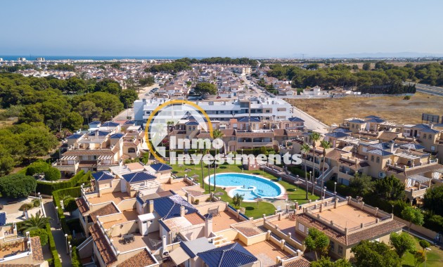 Drone shot of Mil Palmeras apartment development with landscaped gardens, pool and nearby woodland