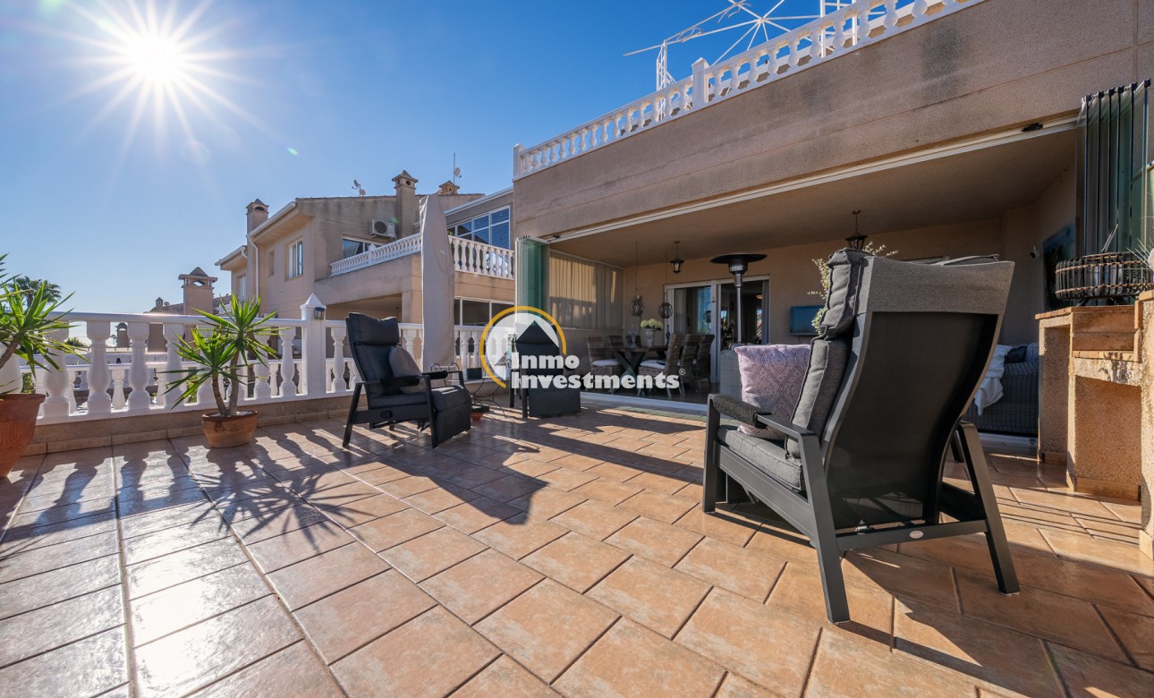 Überdachter Terrassen-Loungebereich mit Terrassenstühlen und Fliesenboden in Duplex-Apartment in Playa Flamenca, Spanien