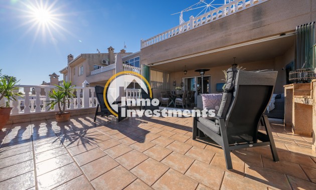 Überdachter Terrassen-Loungebereich mit Terrassenstühlen und Fliesenboden in Duplex-Apartment in Playa Flamenca, Spanien
